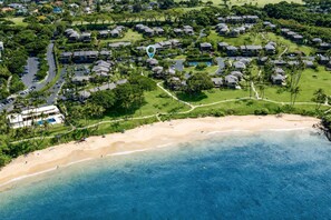 An aerial view of a coastal resort with multiple bungalow-style accommodations, a sandy beach, and a clear blue ocean. - Wailea Elua 1104 - Ocean Views, Central A/C, Walk to Ulua Beach, Shops & Dining! (Kihei)