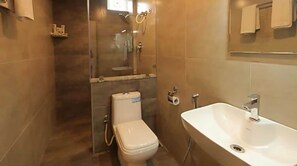 Une salle de bain avec des toilettes, une douche et un lavabo.