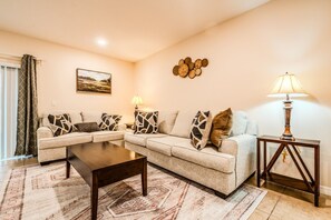 A living room with a sofa set, a coffee table, a lamp, and a rug. - Tranquil Vacations - Kissimmee (Kissimmee)