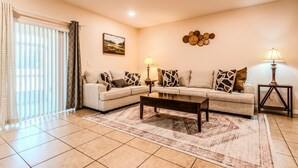 A living room with a sofa set, two side tables with lamps, a coffee table, and a patterned rug. - Tranquil Vacations - Kissimmee (Kissimmee)