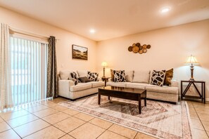A living room with a sofa set, two side tables with lamps, a coffee table, and a patterned rug. - Tranquil Vacations - Kissimmee (Kissimmee)