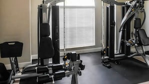 A gym with exercise equipment, a window with blinds, and a tiled floor. - Tranquil Vacations - Kissimmee (Kissimmee)