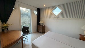 A hotel room with a bed, a desk, a chair, a small table, a lamp, and a window with curtains. - Panoramic ocean view, direct access to a private sandy beach in Skagen South—family-friendly (Ålbæk)