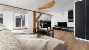 Una sala de estar moderna con un sofá, un televisor y una chimenea.