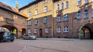 Un edificio histórico con múltiples arcos y un patio empedrado.