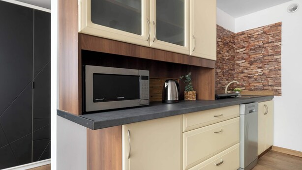 Una cocina moderna con microondas, hervidor y lavavajillas.