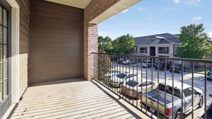 A balcony with a view of a parking lot and buildings. - Relaxing Kingsgate 2BR (Beaumont)