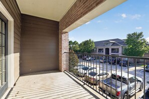 A balcony with a view of a parking lot and buildings. - Relaxing Kingsgate 2BR (Beaumont)