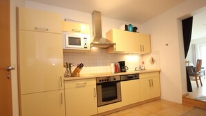A compact kitchen with a microwave, oven, and coffee maker. - Appartement im Seedomizil Kummerow (Kummerow)