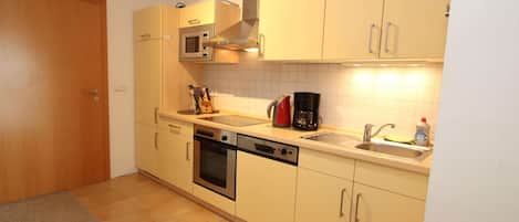 A compact kitchen with a microwave, oven, and dishwasher.