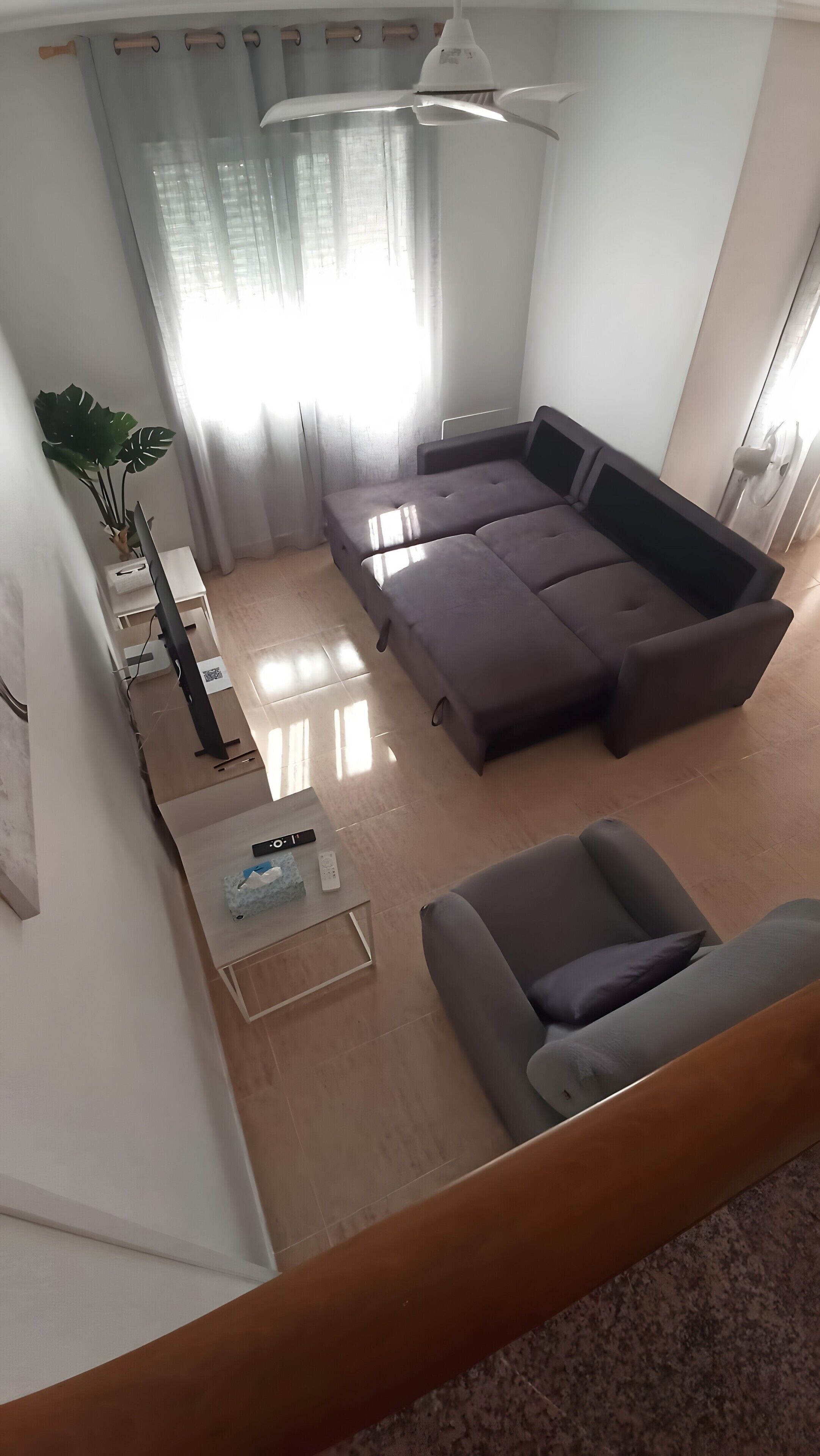 A modern living room with a sectional sofa, a coffee table, and a TV stand.