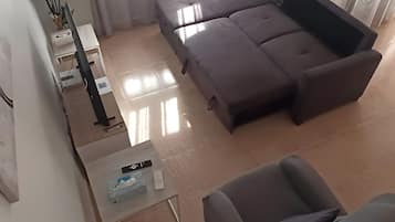 A modern living room with a sectional sofa, a coffee table, and a TV stand.