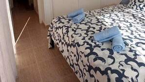 A bedroom with a bed, a wardrobe, and a ceiling fan.