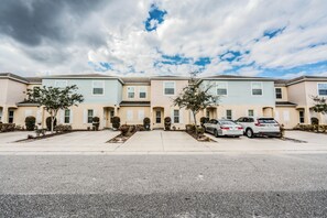 A row of townhouses with a parking area in front. - Tranquil Vacations (Kissimmee)