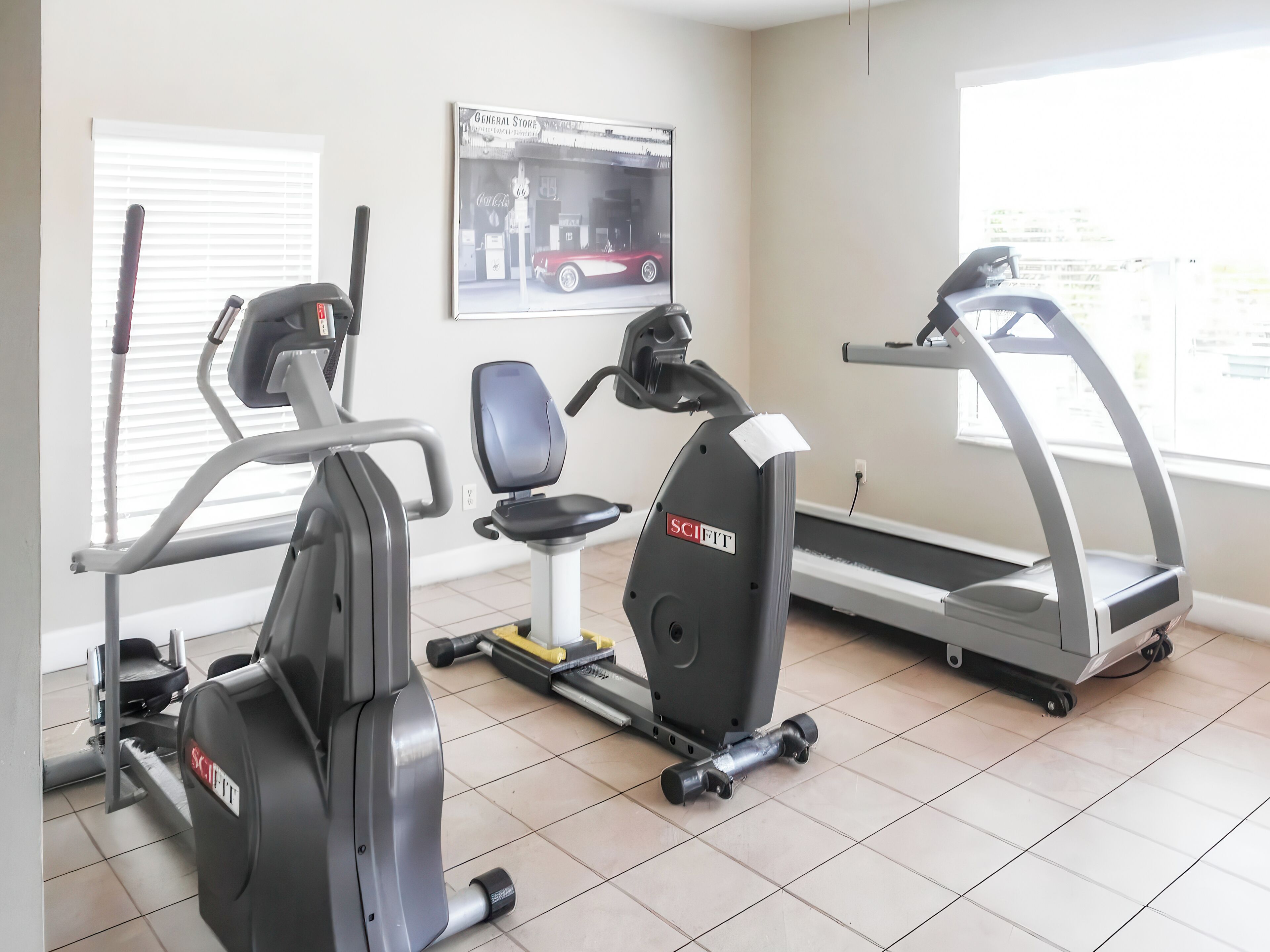 Ein Fitnessraum mit Ergometer, Laufband und Rudergerät.