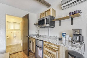 A compact kitchen with a built-in microwave, a coffee maker, and a refrigerator. - Aspen Room | Kitchenette in Manitou Springs, CO (Colorado Springs)