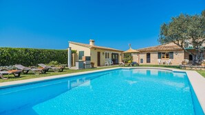 A swimming pool with lounge chairs and a building with a tiled roof. - Peaceful Rural Haven With Pool (Pollença)