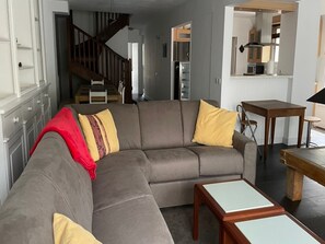 A modern living room with a sectional sofa, a dining area, and a kitchen in the background. - Spacious apartment 8-12 guests with slope view (Gourette)