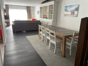 A modern living space with a dining area, sofa, and a white cabinet. - Spacious apartment 8-12 guests with slope view (Gourette)