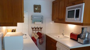 Una cocina con armarios de madera, microondas, tostadora y lavavajillas.