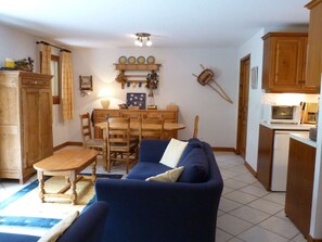 A compact living space with a sofa, dining table, chairs, and a kitchenette. - Charming apartment at the foot of the slopes - 6 guests (Arêches-Beaufort)