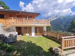 A wooden chalet with a balcony overlooking a mountainous landscape. - Spacious apartment mountain view - 5 guests (La Clusaz)