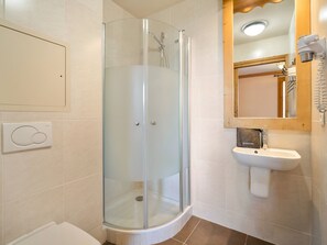 A bathroom with a glass-enclosed shower, a white sink, and a mirror above the sink. - Spacious central apartment - 10 guests (Val Thorens)
