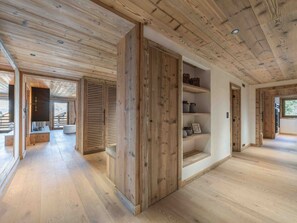 A spacious room with wooden flooring, a built-in shelf unit, and a large sliding door. - Cozy ski-in/ski-out apartment - ? guests (Méribel)
