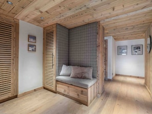 Ein Zimmer mit eingebautem Sitzbänkchen, Holzboden und Holzbalkendecke.