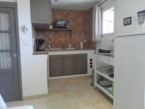 A compact kitchen with a microwave, coffee maker, and a sink.