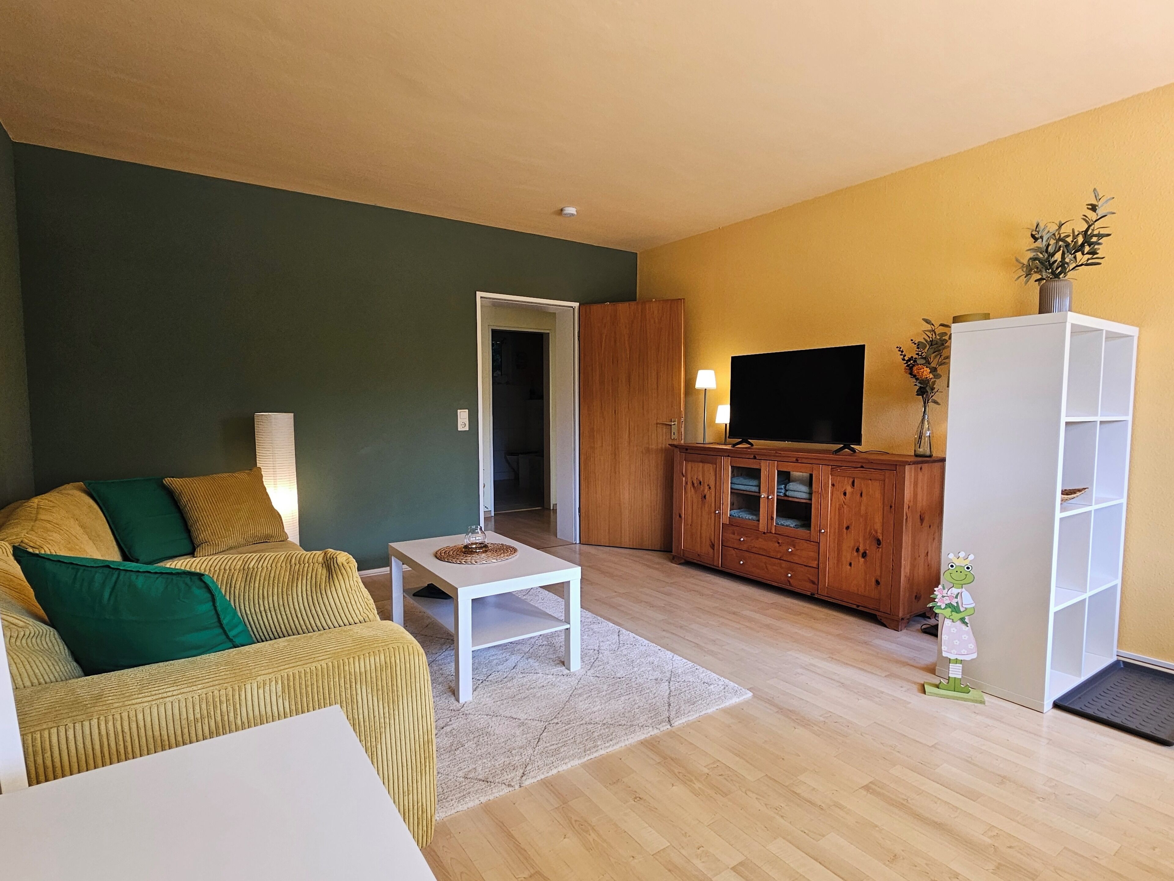 Ein Wohnzimmer mit Sofa, Couchtisch, TV-Schrank und Schrank.