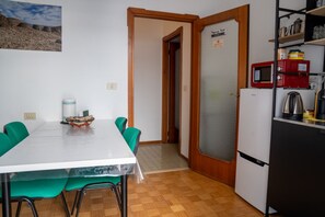 Eine kleine Küche mit Kühlschrank, Mikrowelle und einer Kaffeemaschine.