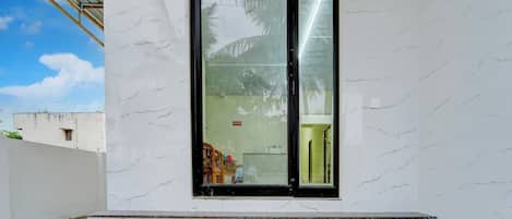 A building entrance with a glass door, a reception area visible inside, and a set of steps leading up to the door.