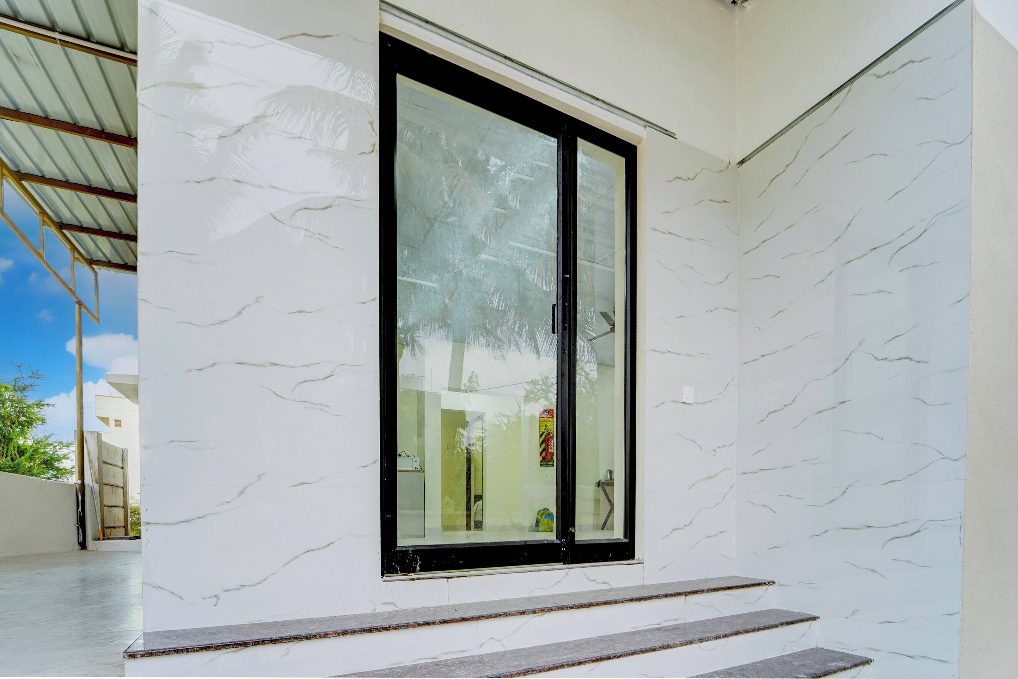 A modern building with a large glass door and a white marble exterior.