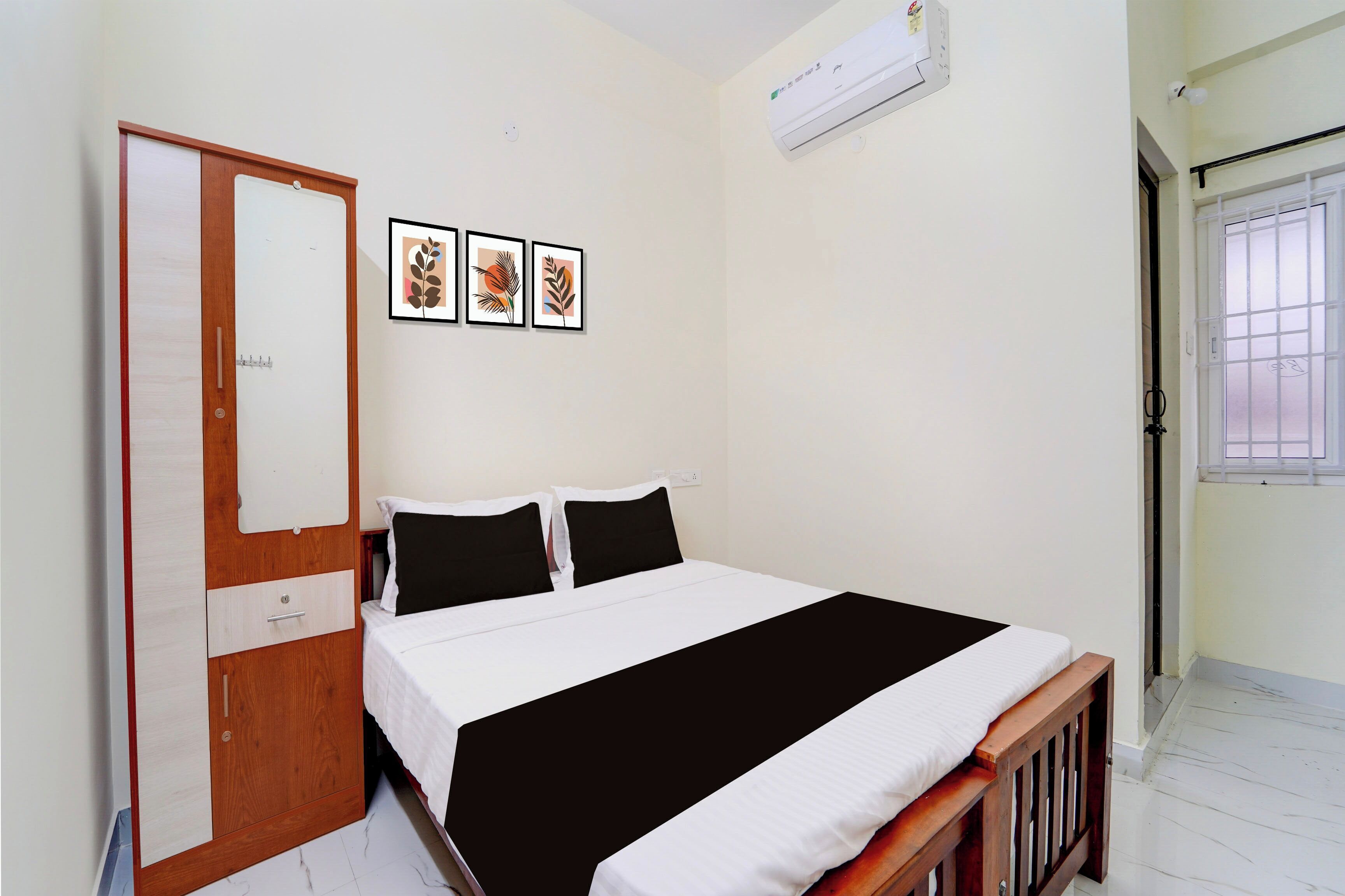 Un dormitorio con cama, armario, ventana y aire acondicionado instalado en la pared.