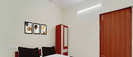 A bedroom with a bed, a wardrobe, and a door.