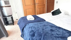 Quarto com cama, armário e aquecedor.