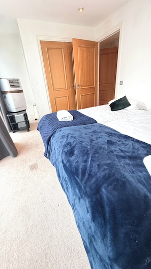 Ein Schlafzimmer mit einem Bett, einem Kleiderschrank und einem Heizgerät.