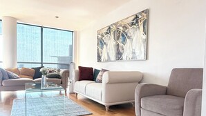 Uma sala de estar moderna com um sofá, uma mesa de centro e um quadro na parede.
