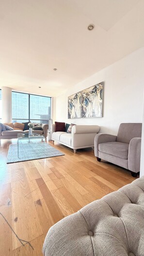 Ein modernes Wohnzimmer mit einer Couch, einem Couchtisch und einem Bild an der Wand.