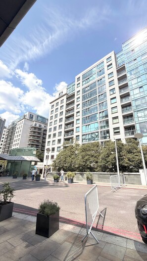Ein mehrstöckiges Gebäude mit moderner Architektur, mit Balkonen und großen Fenstern.