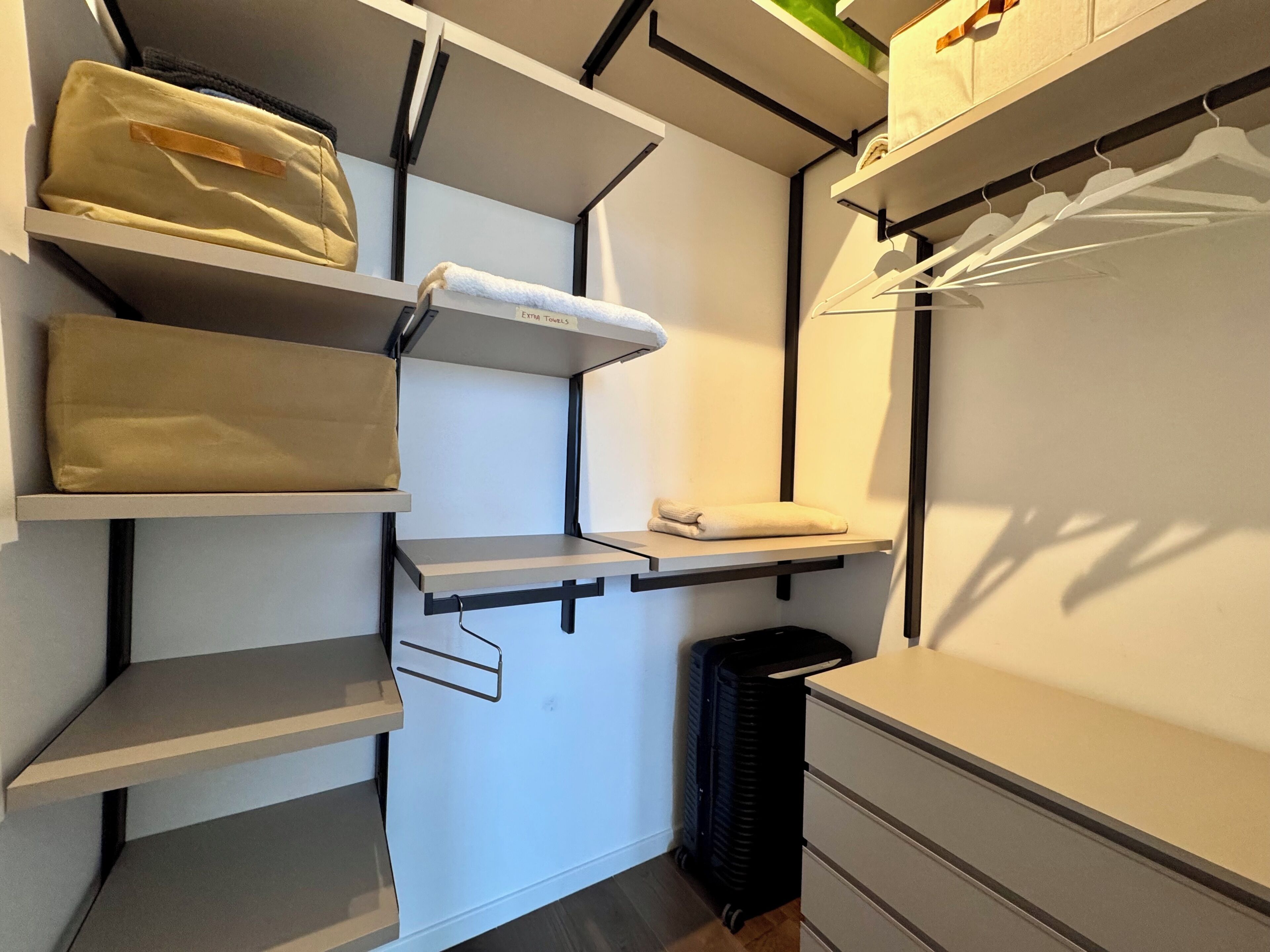 Un meuble de rangement compact doté de plusieurs étagères et de tiroirs, et comprenant une section étiquetée « TOILETTES SUPPLÉMENTAIRES ».