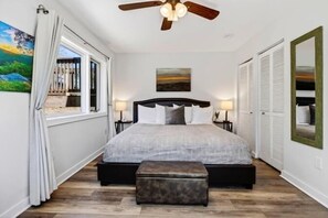 A bedroom with a bed, a ceiling fan, a window with curtains, and a painting on the wall. - Ledges 50 with Wintergreen Advantage (Wintergreen)