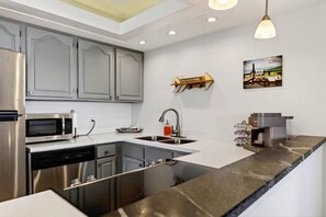 A modern kitchen with stainless steel appliances, a granite countertop, and a built-in dishwasher. - Ledges 50 with Wintergreen Advantage (Wintergreen)