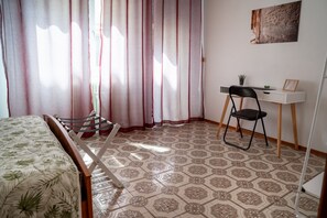 A room with a bed, a desk, a chair, and a window with curtains. - A practical room within an 84-square-meter unit—perfect for two people—located on the ground floor of an Art Nouveau building.The property is situated in a quiet area of ​​Ravenna that is also strategically located for sightseeing: the city cente (Ravenna)