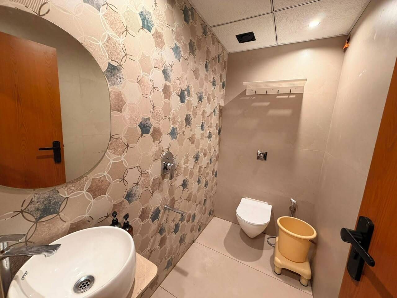 Baño con lavamanos, inodoro y espejo.