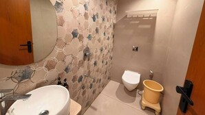 A bathroom with a sink, toilet, and mirror. - Hotel Rio Valley (Rajkot)