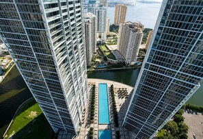 A high-rise building with a swimming pool and a river in the background. - Incredible 1 Bedroom Apt 43rd Floor at Icon Brickell (Miami)