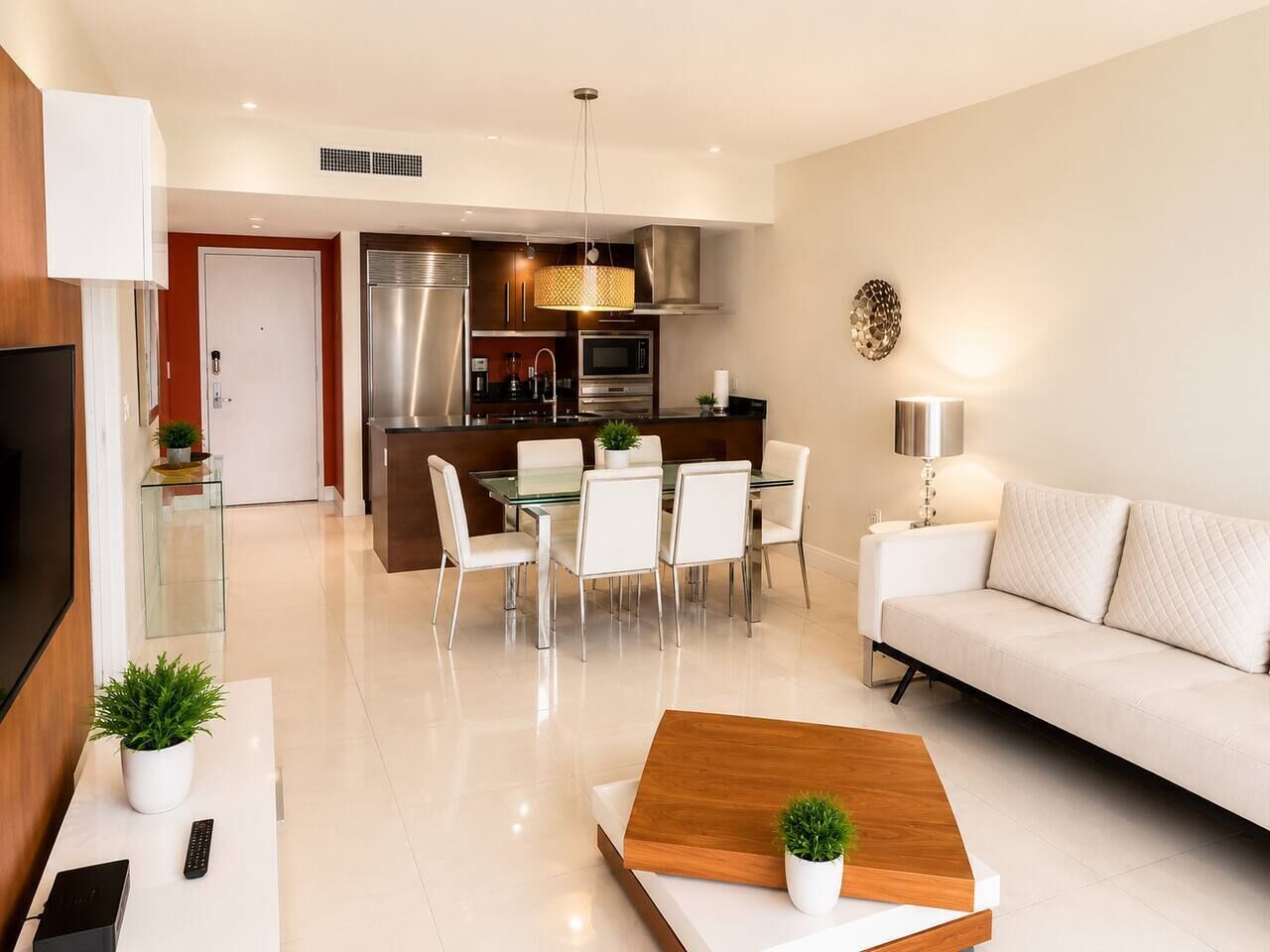 A modern living room with a sofa, a coffee table, and a dining area with chairs and a table.