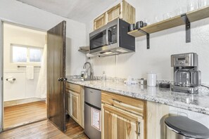 A compact kitchen with a microwave, coffee maker, and wooden cabinets. - Pet-Friendly Juniper Room Near Garden of the Gods (Colorado Springs)